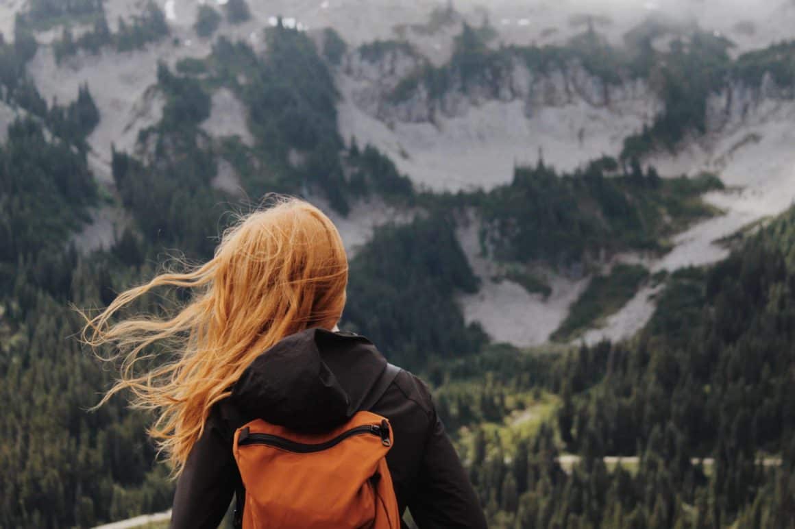 Woman with hair blowing in wind overlooking mountains