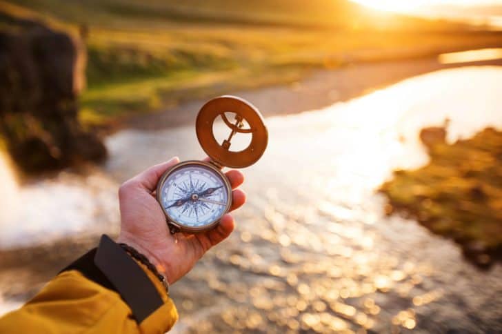 Person holding compass in travel destination