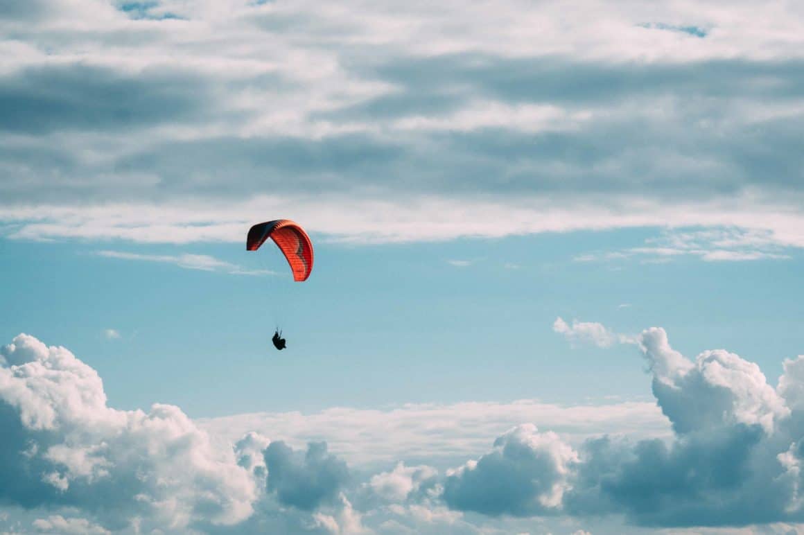 Person paragliding through the sky.