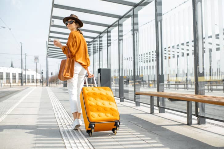 Woman at airport with orange luggage